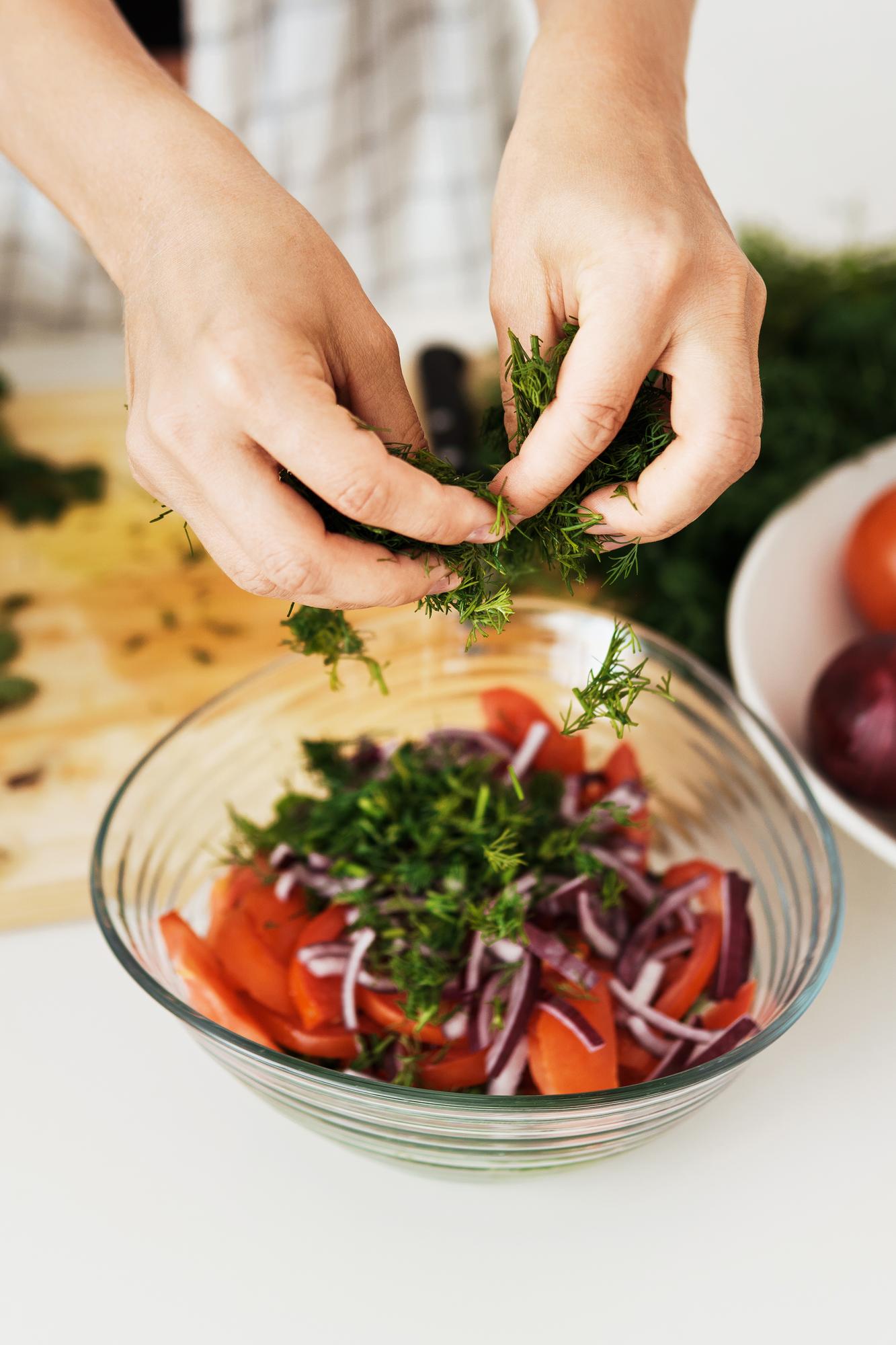 hands preparing a rustic seasonal salad